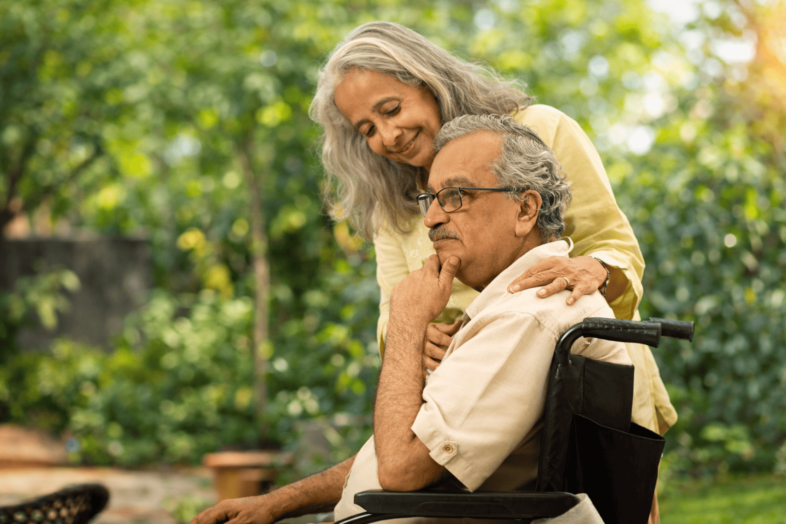 Caregiver providing compassionate neurological care to an elderly resident with movement disorders